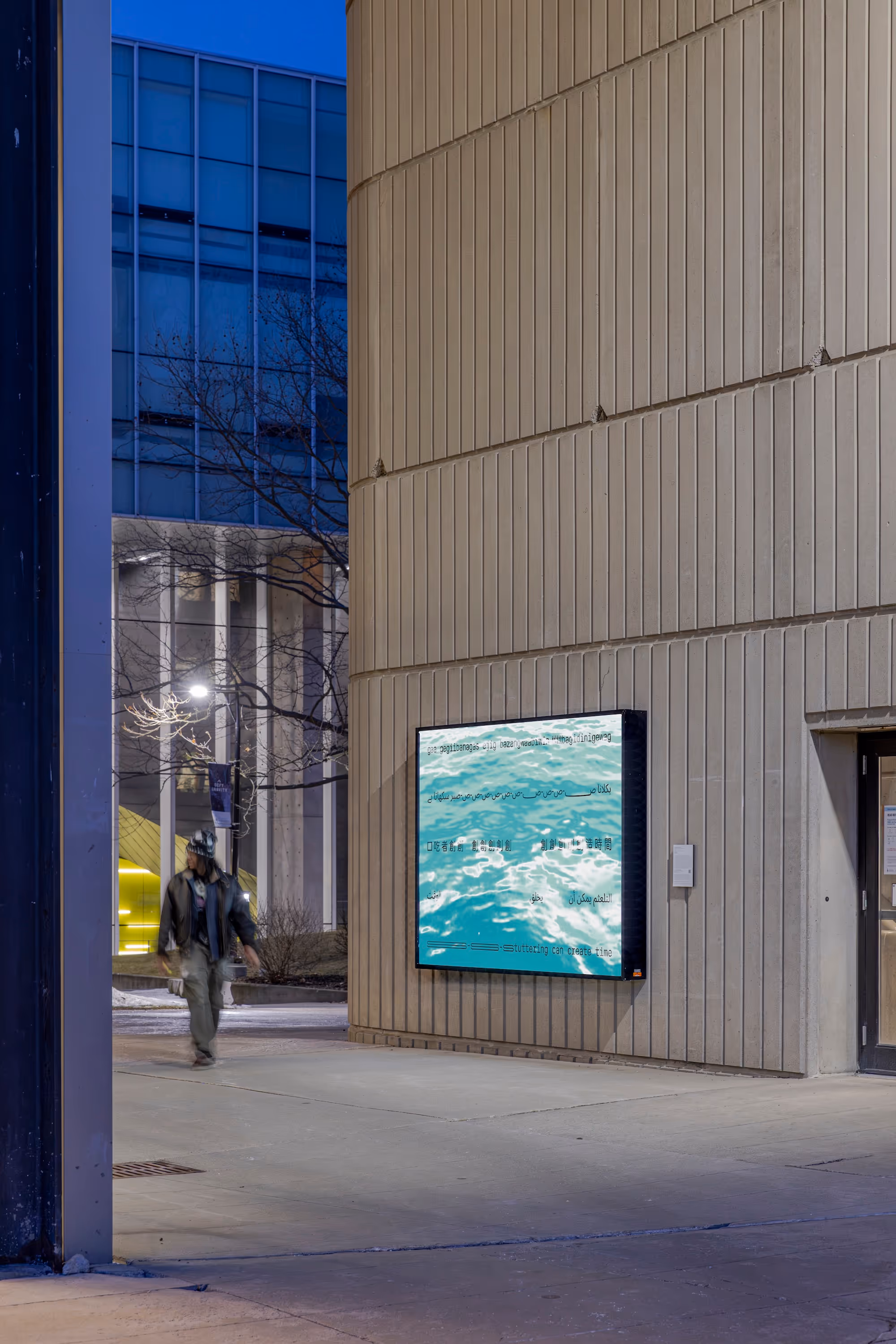 Light shines off the surface of the water. The image is derived from a photograph designer Conor Foran took of Lake Ontario. The text is in a sans-serif typeface organized in five evenly spaced lines, each representing a form of stuttered speech: repeated syllables, repeated words, blocks (pauses in speech), and prolonged syllables. The first line, in Anishinaabemowin, translates to “Stutterers allow/offer a moment.” The word bagidinigeweg ("they allow/offer") is preceded by six overlapping b’s, representing a repetition on the letter b. The second line, in Urdu, translates to “Stuttering teaches patience.” The letter at the beginning of the word صبر ("patience") is stretched and repeats 10 times in a row, representing prolonged sound and repetition. The third line, in Chinese, translates to “People who stutter create time.” The character 創 (the first character of a Chinese word that translates to “create”) appears twelve times in a row, representing repetition. There are intentional spaces after the second and seventh appearance of this character, representing blocks in speech. The fourth line, in Arabic, translates to “Stuttering can create time.” There is an intentional space between التلعثم يمكن أن ("stuttering can") and يخلق ("create"), and an even larger space before الوقت ("time"), representing blocks in speech. The fifth line, in English, reads "Stuttering can create time." The “s” in “stuttering” is stretched horizontally to represent prolonged sound. The Anishinaabemowin and English lines are all lowercase and lack punctuation, giving a casual and informal, almost text message-like feel.