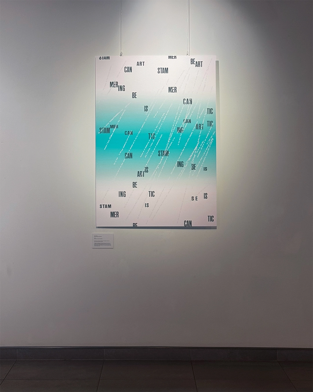 A large poster on a wall. It features a blue and white gradient and a flurry of black typography, reading ‘Stammering Can Be Artistic.’