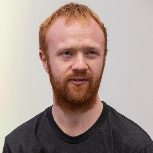 A portrait of Patrick Campbell: he is wearing a t-shirt, and is looking off into the distance, as he speaks.